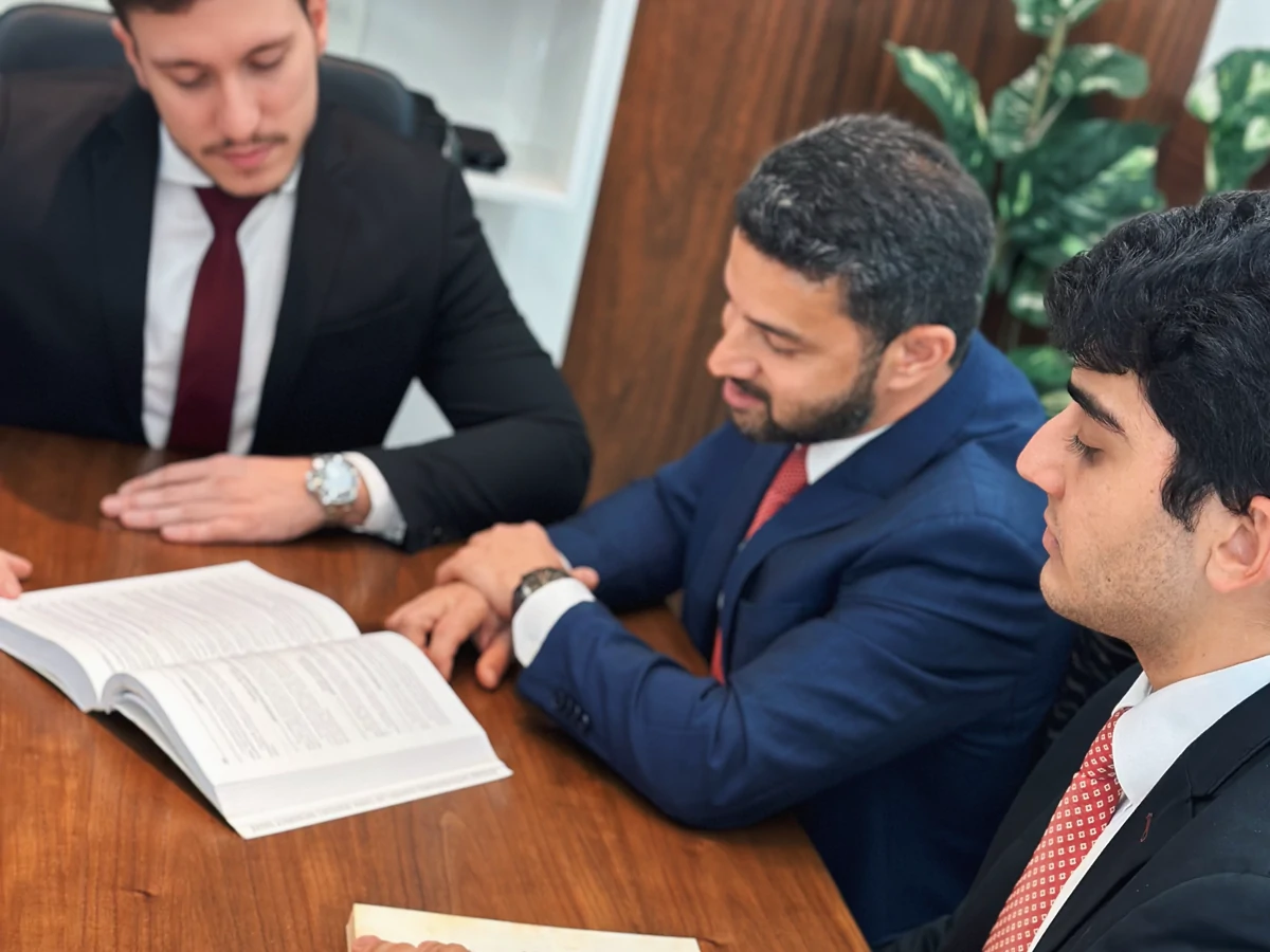 Os sócios da MJD Advogados reunidos em mesa de trabalho